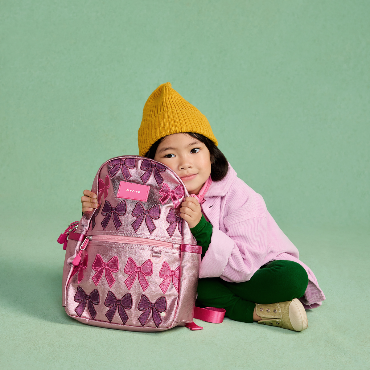 girl sitting with STATE Bags Kane Mini Bows