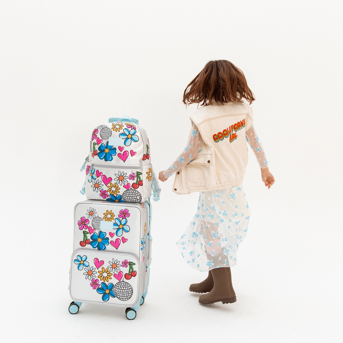 Girl wearing STATE Bags Kane Backpack and Logan Suitcase Metallic Graffiti 