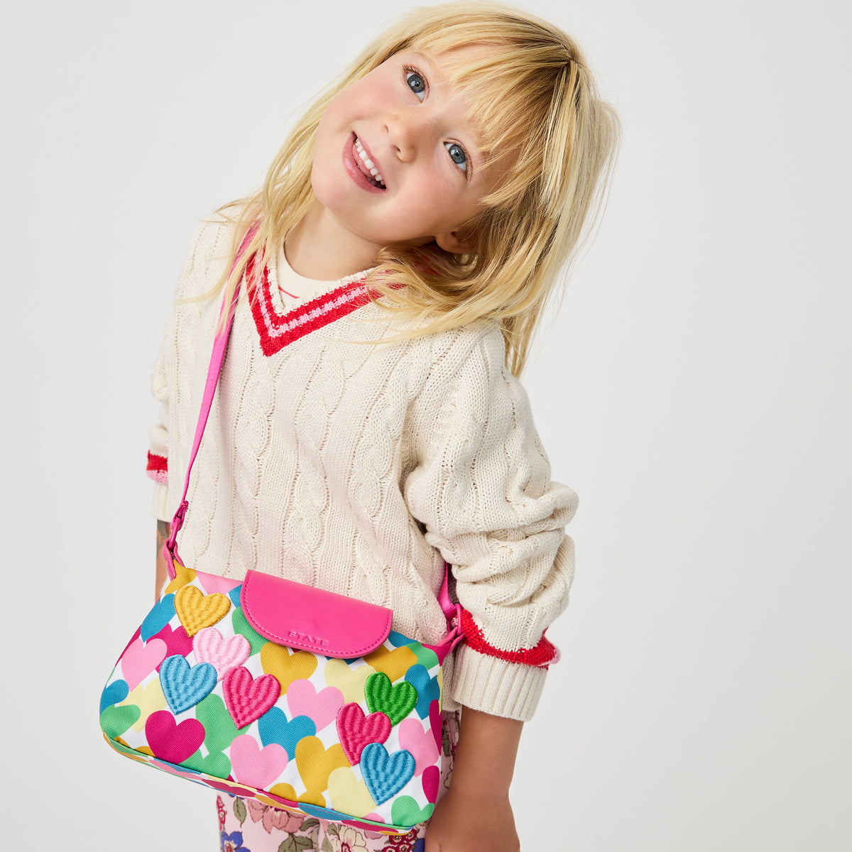 Girl wearing STATE Bags Chelsea Pouchette Happy Fuzzy Hearts 