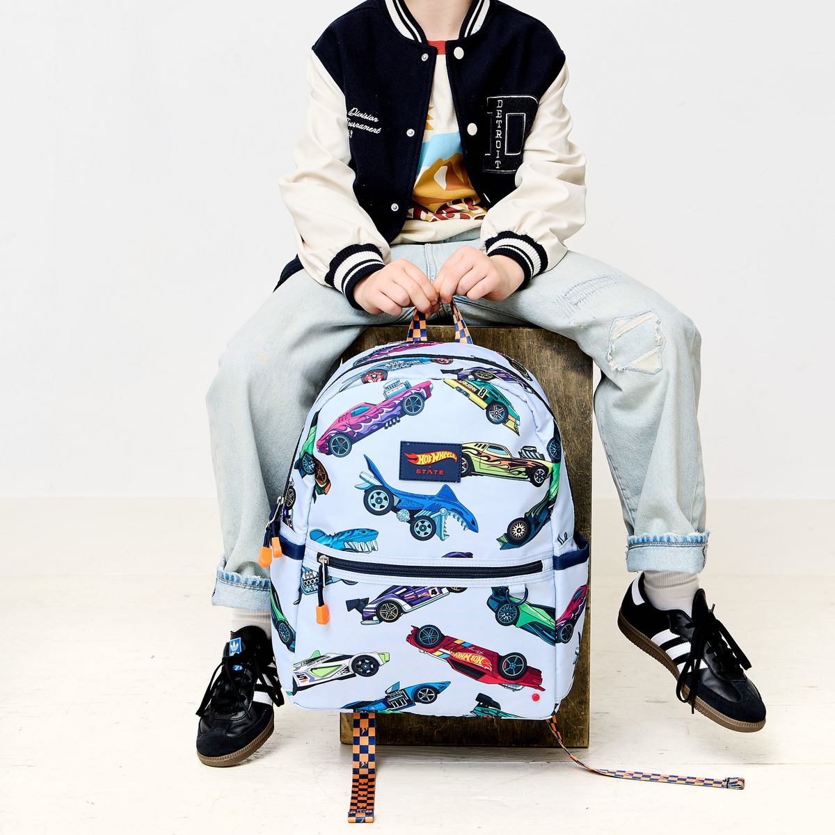 Boy holding STATE x Hot Wheels Kane Backpack Hot Wheels Cars 