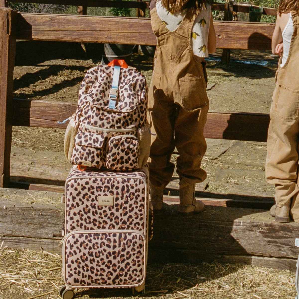 girl with STATE Bags Logan Carry-On Suitcase Leopard 