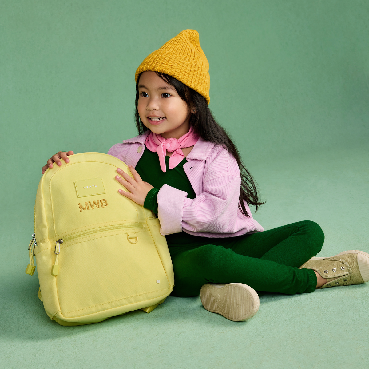 girl wearing kane mini backpack butter yellow