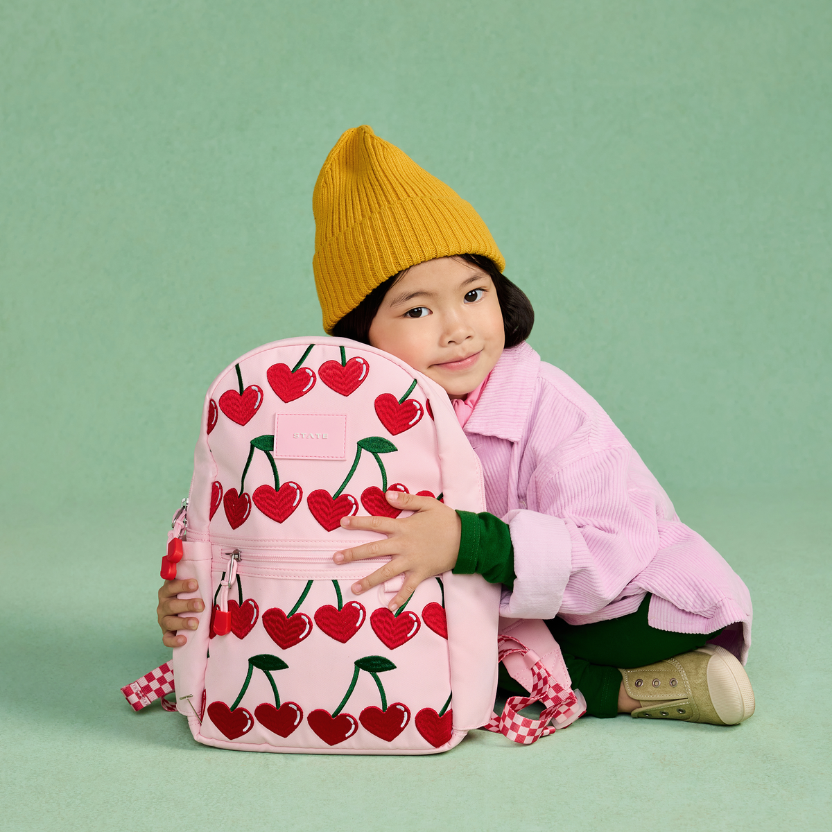 girl wearing STATE Bags Kane Mini Backpack Cherry