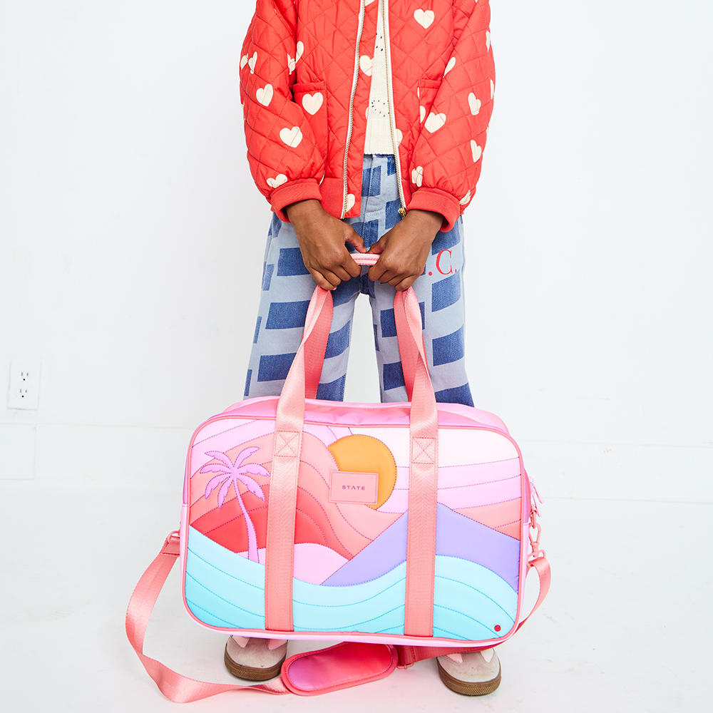 Girl Holding STATE Bags Rockaway Duffle in Sunset